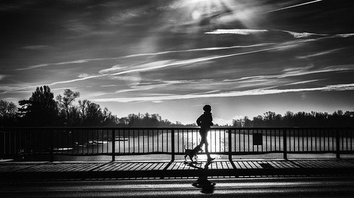 silhouette of a person running next to a lake