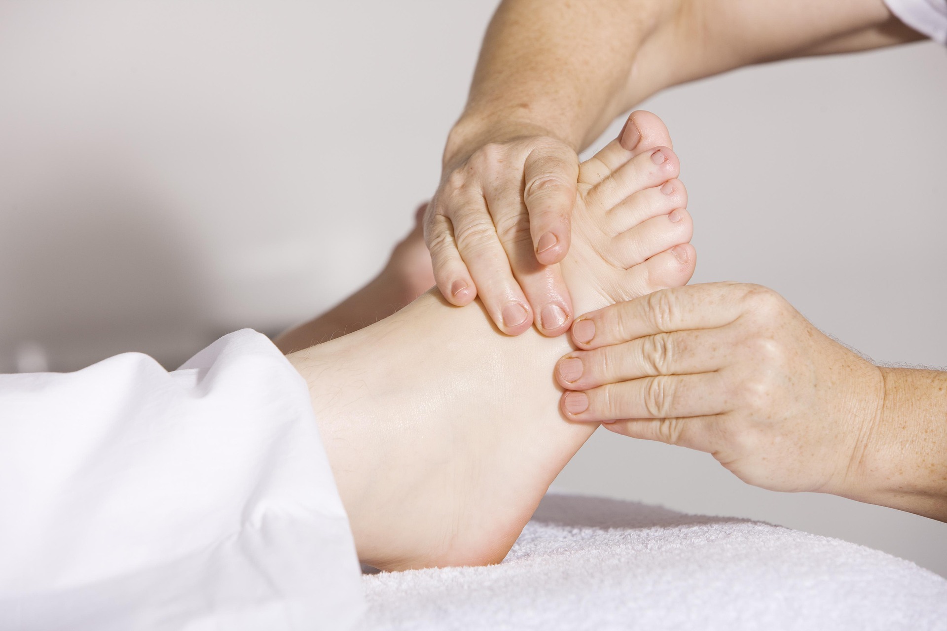 massage therapist performing foot massage to treat heel pain caused by plantar fasciitis